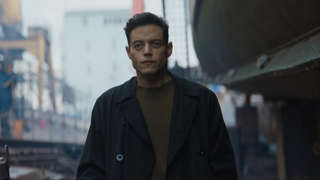 Rami Malek stands and stares.