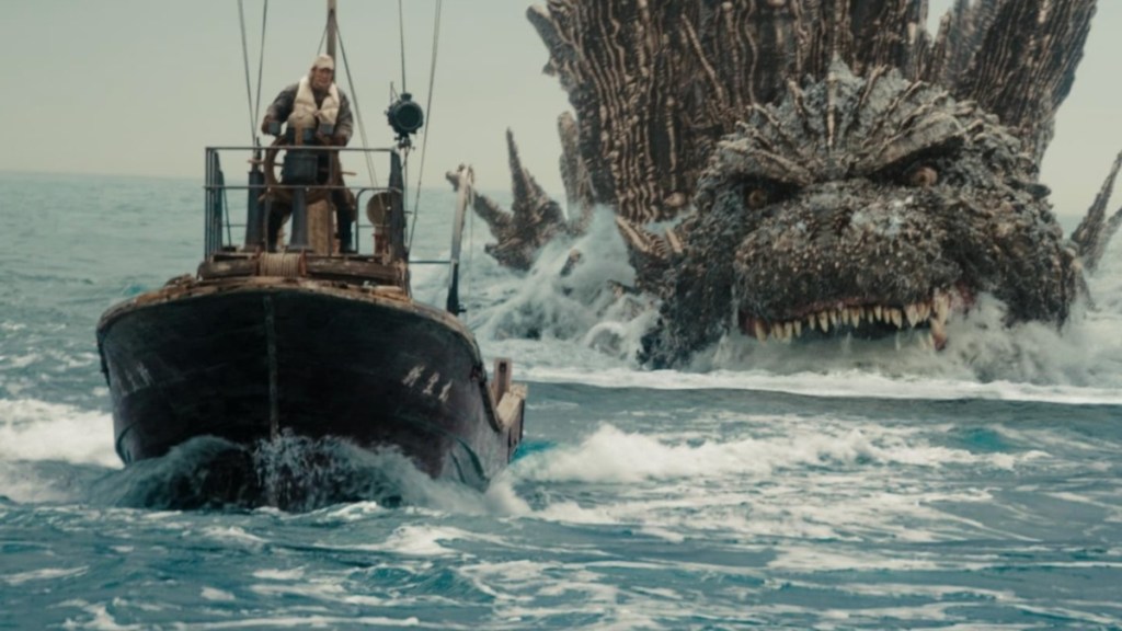 Godzilla swims after a ship.