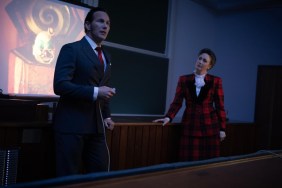 A man and woman stand in front of a projector.