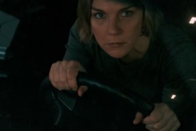 A woman holds the steering wheel of her car.