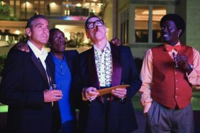 A group of men stand next to each other nad look up.