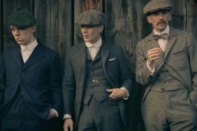 A group of men stand against a wall.