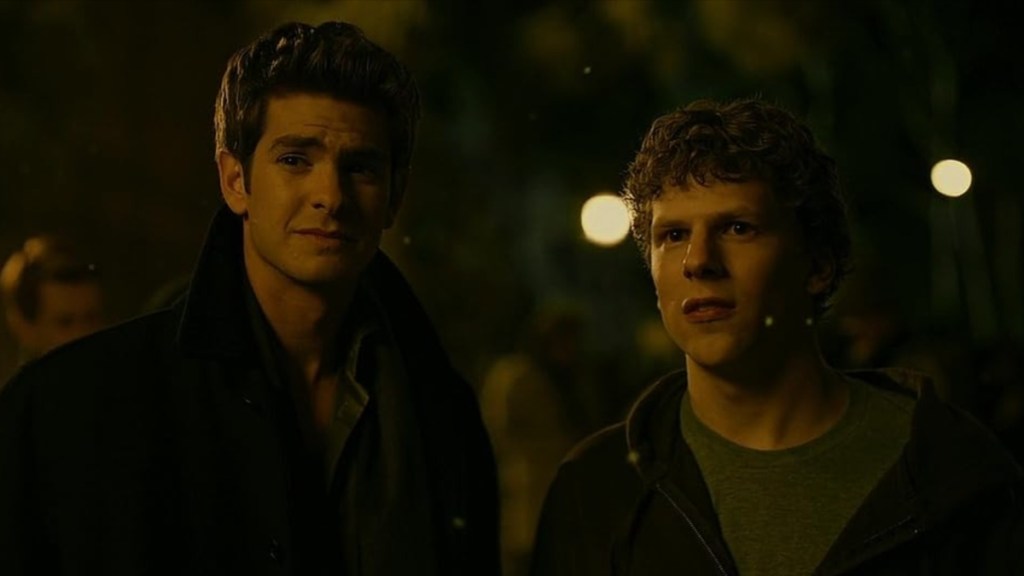 Two men stand next to each other and stare.