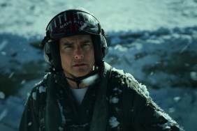Tom Cruise looks up with a helmet on.