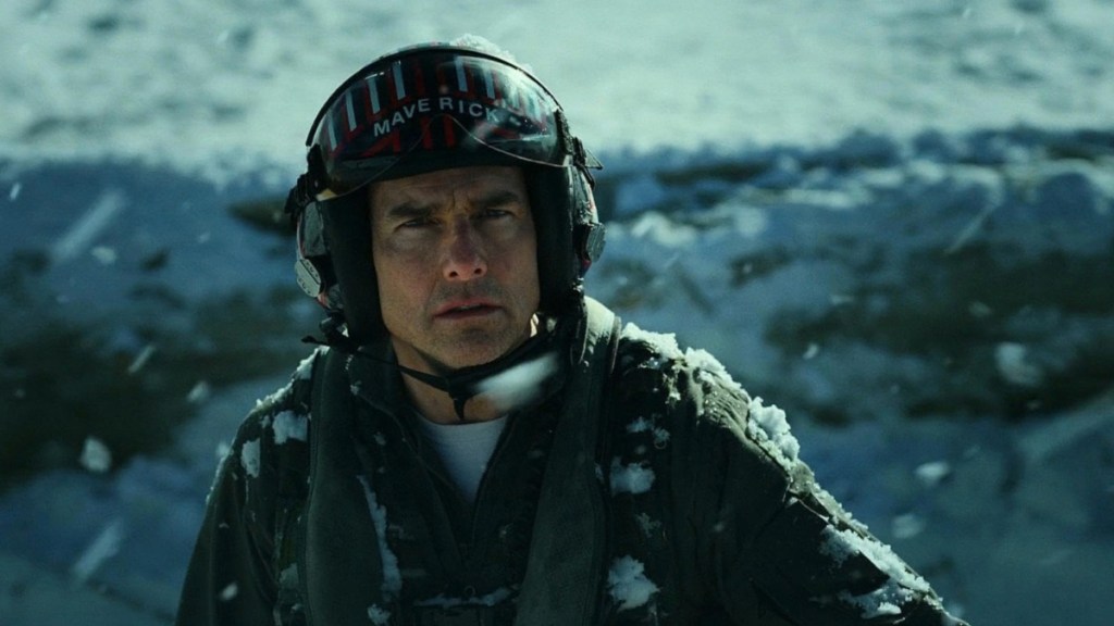 Tom Cruise looks up with a helmet on.