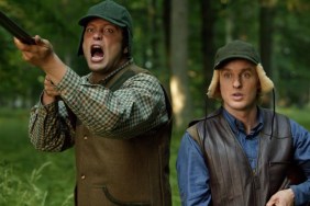 A man points a gun next to another guy.