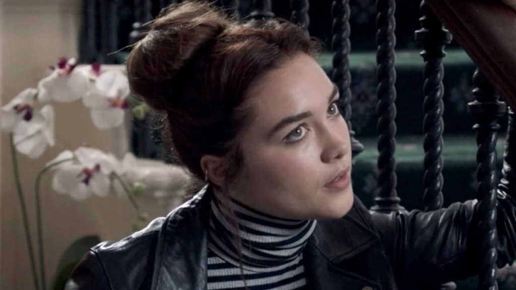 Florence Pugh leans and stares in Malevolent.