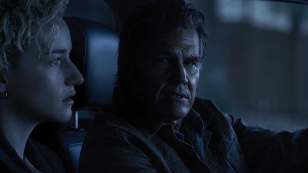 A man and woman sit in the car in Weapons.