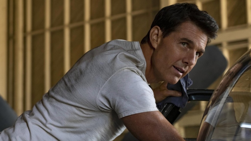 Tom Cruise leans up against a bike in Top Gun: Maverick.