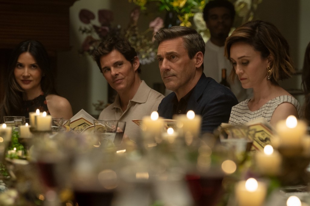 A group of people sit at a table in Your Friends & Neighbors Season 2.