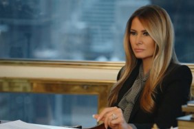 Melania Trump sits behind her desk.