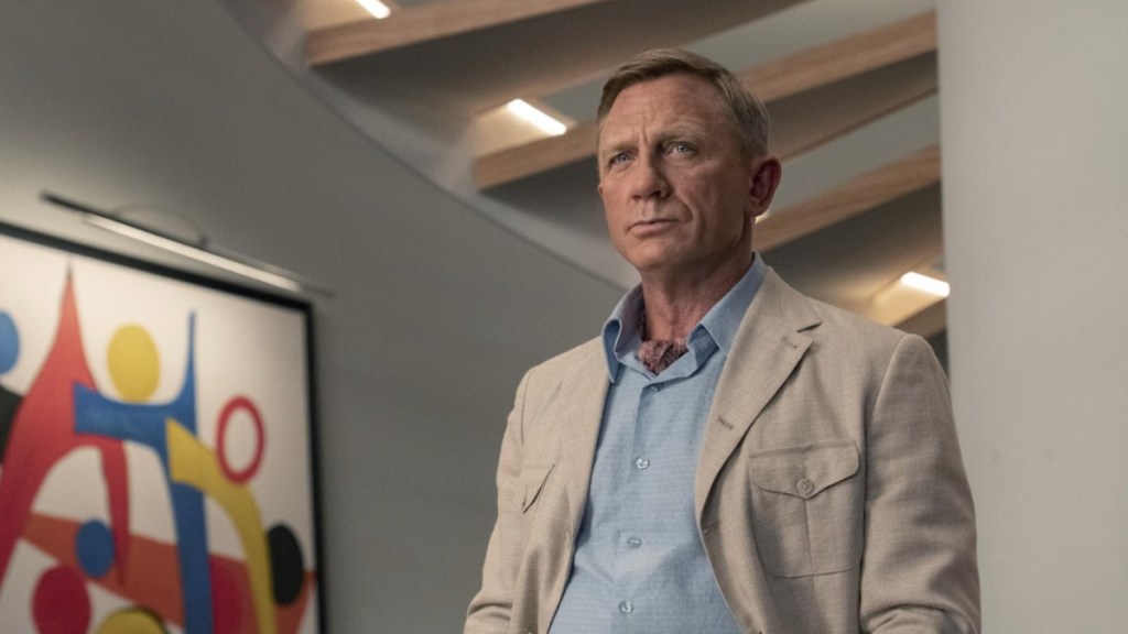 Daniel Craig stands against a wall in Glass Onion.