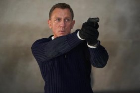 Daniel Craig points a gun as James Bond in No Time to Die.