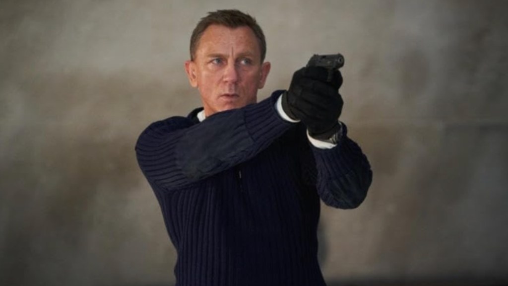 Daniel Craig points a gun as James Bond in No Time to Die.