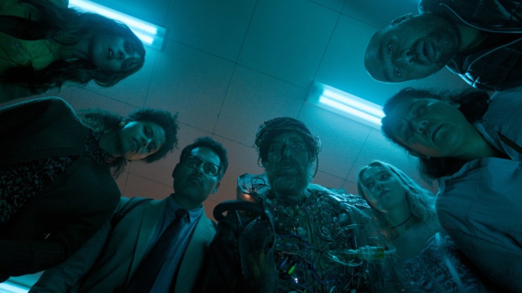Sam Rockwell and a crew of people stand in a circle in Good Luck, Have Fun, Don't Die.