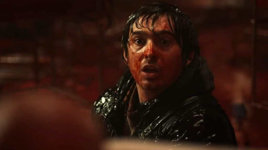 A bloodied Austin Abrams looks along in Resident Evil.