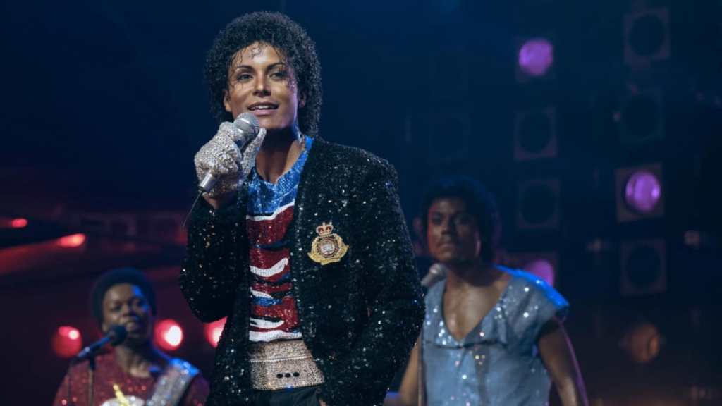 Jaafar Jackson holds up a mic in Michael.