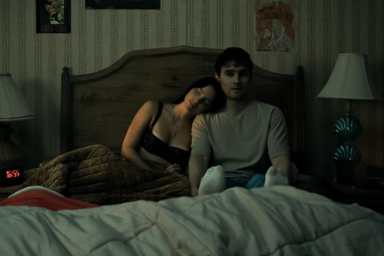 A girl leans up against a guy in Obsession.
