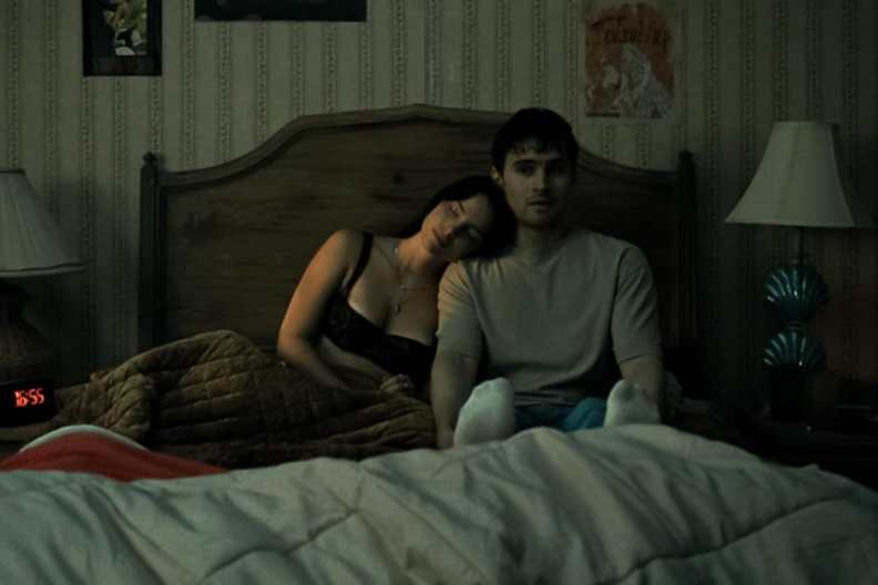 A girl leans up against a guy in Obsession.