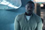 Idris Elba walks down an aisle in Hijack.