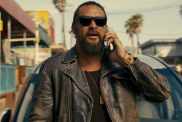 Jason Momoa holds a phone to his head in The Wrecking Crew.