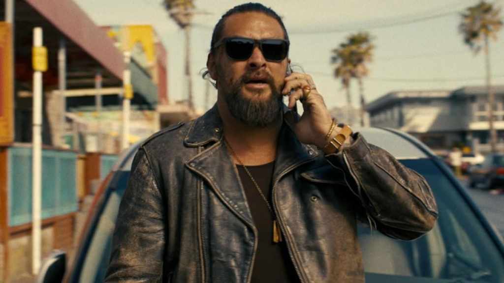 Jason Momoa holds a phone to his head in The Wrecking Crew.