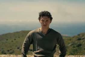 Tom Holland leans against a rock.