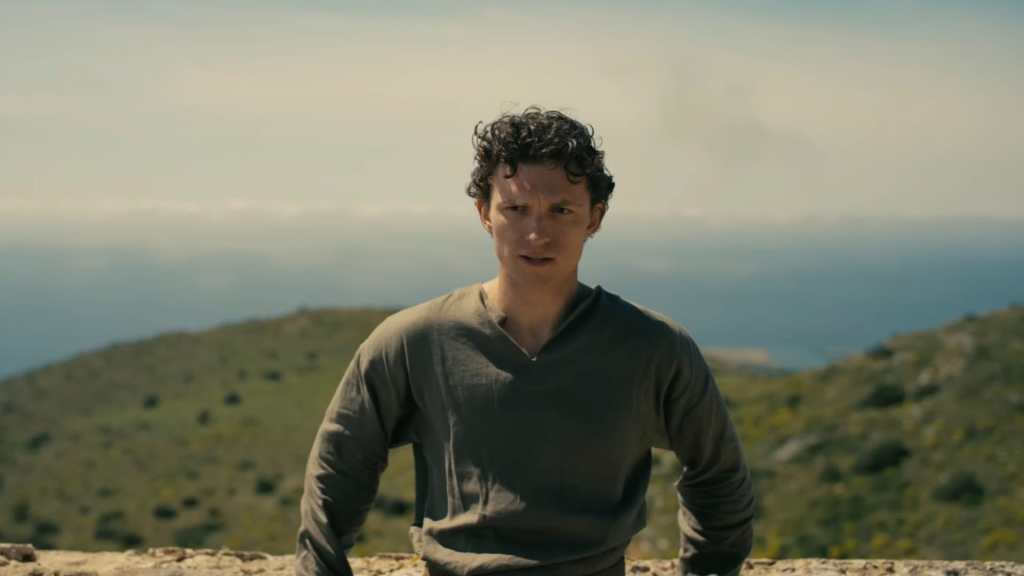 Tom Holland leans against a rock.