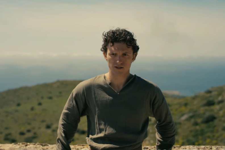 Tom Holland leans against a rock in The Odyssey.