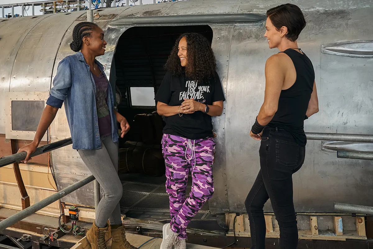 THE OLD GUARD (2020) L-R: KIKI LAYNE, Director GINA PRINCE-BYTHEWOOD, CHARLIZE THERON on the set of THE OLD GUARD. 

Photo Credit: AIMEE SPINKS/NETFLIX Â©2020